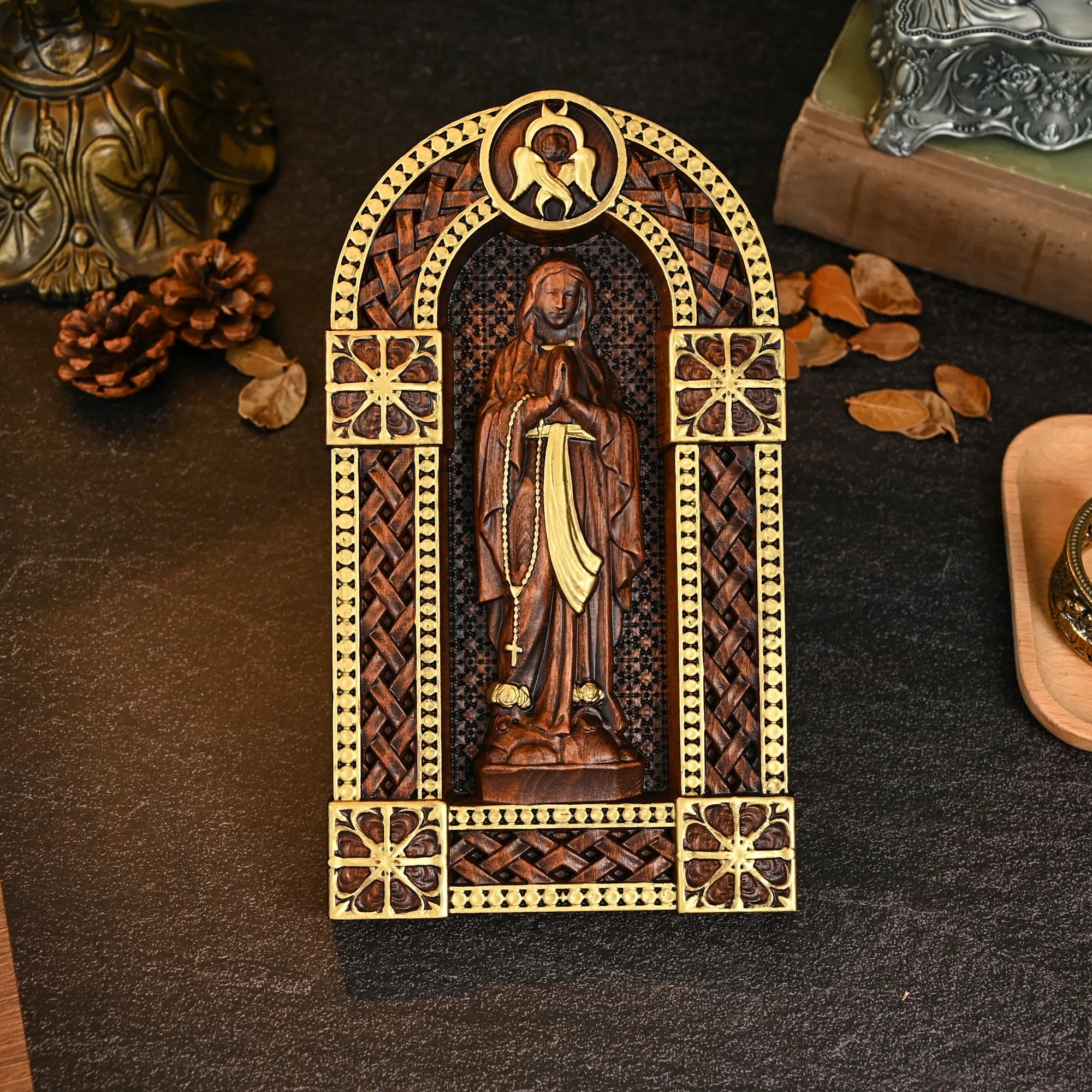Imagem de Nossa Senhora em oração esculpida em relevo no oratório de madeira