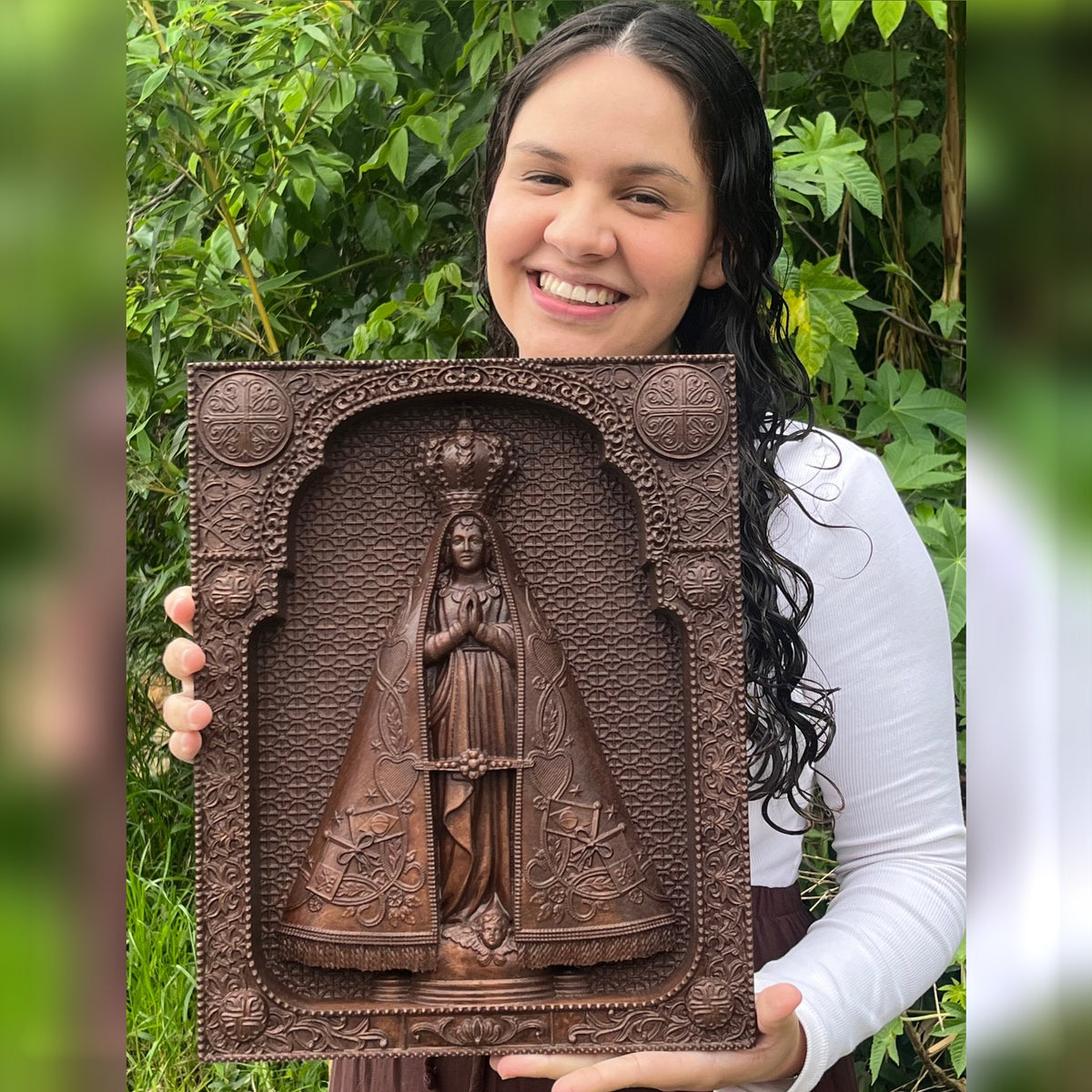Quadro de Nossa Senhora Aparecida em Madeira marrom nas mãos, mostrando o tamanho real - Sagrado Tesouro